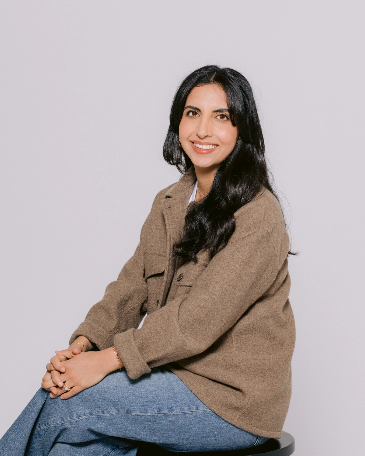 Talia Mann seated in a brown jacket
